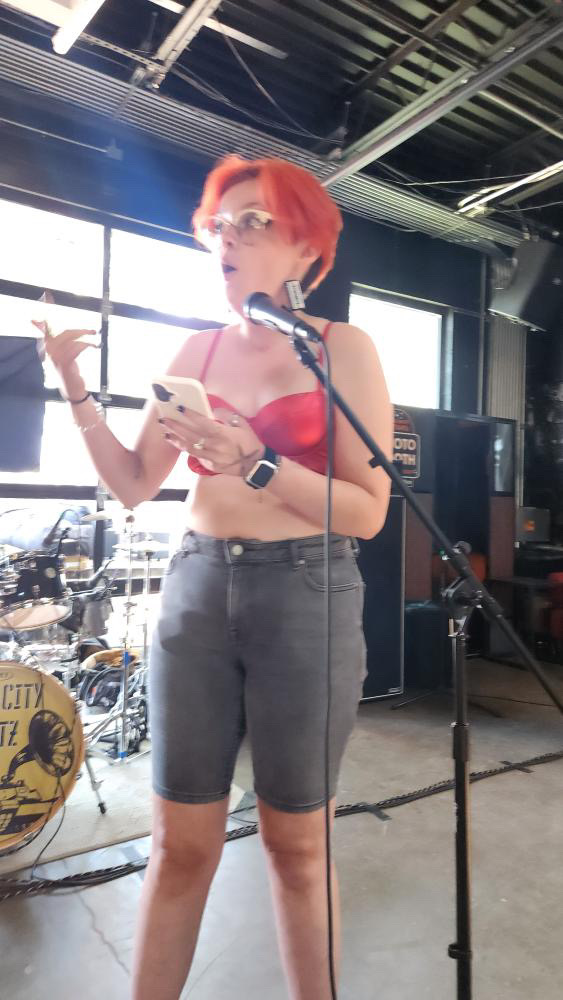 Red haired woman in red top singing